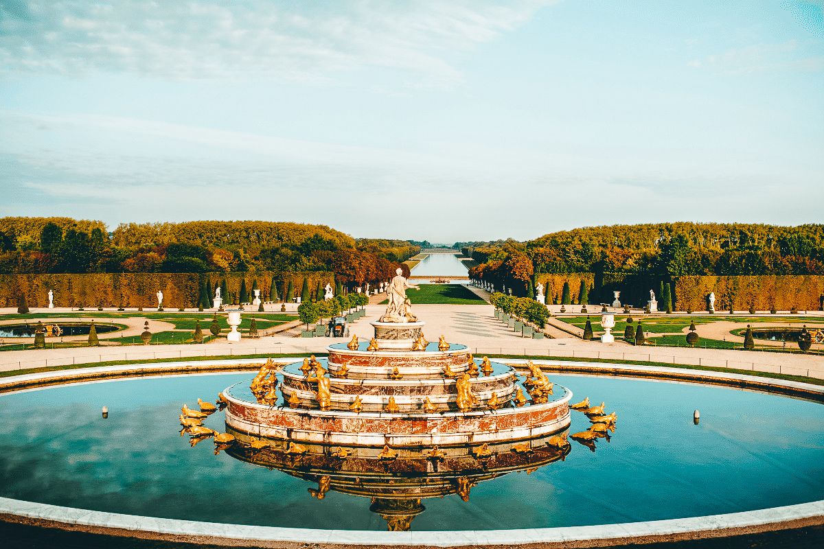 A water fountain facing down towards a garden filled with trees