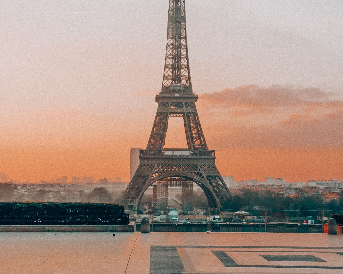 The eiffel tower at sunset in front of a court yard