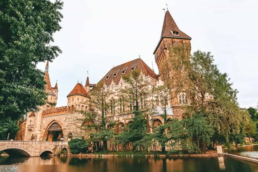 A bridge crossing a river to a castle surrounded by trees