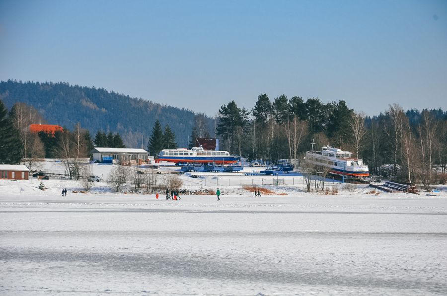 Frozen Lake Lipno covered in snow and surrounded by boats